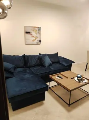 a living room with a blue couch and a table at Modern 2BDRM in 5* Resort & pool in Sandanski