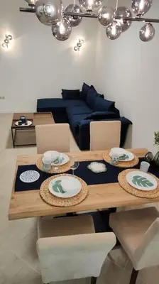 a living room with a table and a blue couch at Modern 2BDRM in 5* Resort & pool in Sandanski