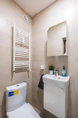 a bathroom with a white toilet and a sink at Orange friendly apartment near Vitosha blvd in Sofia