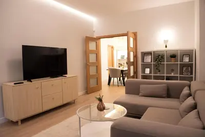 a living room with a flat screen tv on a cabinet at Top Center Designer Apartment in Sofia