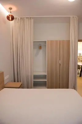 a bedroom with a white bed and a closet at Top Center Designer Apartment in Sofia