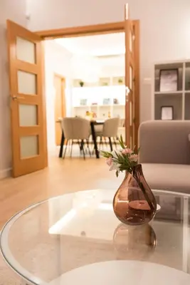 a vase with flowers sitting on a glass table at Top Center Designer Apartment in Sofia