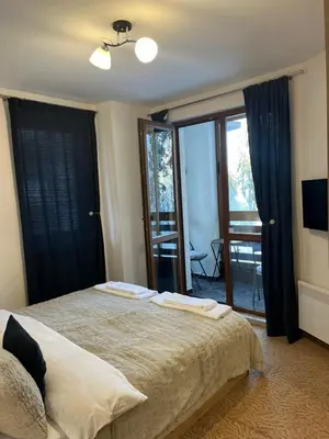 a bedroom with a bed with two towels on it at Elizi winter apartments Pamporovo in Pamporovo