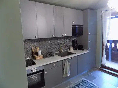 a kitchen with white cabinets and a sink and a window at La'Vista in Smolyan