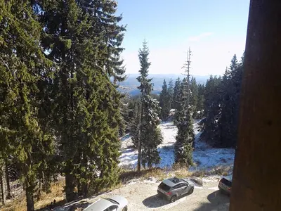 two cars parked in a parking lot in the snow at La'Vista in Smolyan