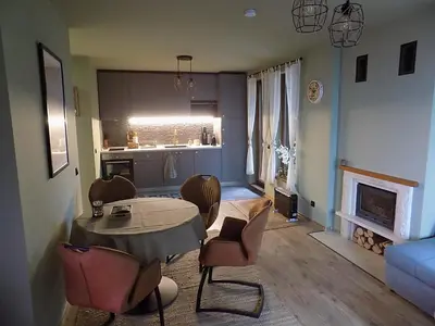 a living room with a table and chairs and a kitchen at La'Vista in Smolyan