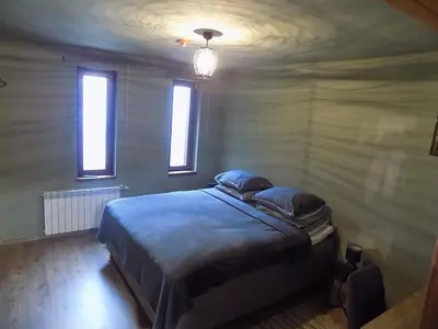 a bedroom with a bed with two pillows and two windows at La'Vista in Smolyan