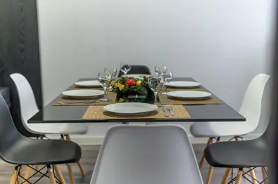 a black table with white plates and wine glasses at PARADISE RELAX APARTMENT in Bansko