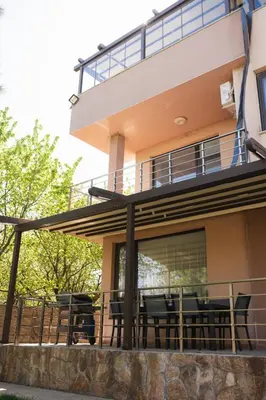 a house with a balcony with tables and chairs at Вила Маунтайн Вю in Brestnik