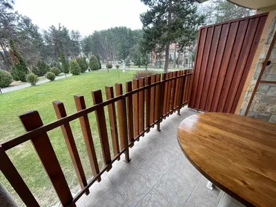 a balcony with a wooden fence and a wooden table at Nikol 3 SPA CLUB BOR in Velingrad