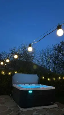 a jacuzzi tub sitting under lights at night at Къща за гости Вила Смокиня град Хисаря in Hisarya