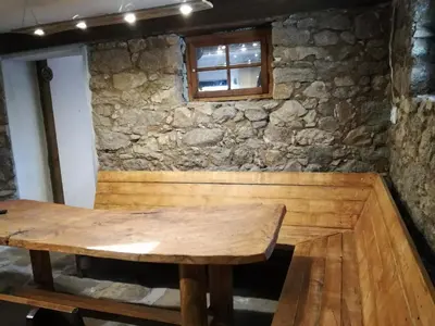 a wooden table in front of a stone wall at Къща за гости Вила Смокиня град Хисаря in Hisarya