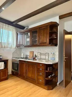 a kitchen with wooden cabinets and a counter top at Уникален апартамент с изглед към планината in Bansko
