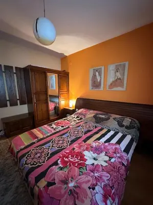 a bedroom with a bed with flowers on it at Уникален апартамент с изглед към планината in Bansko