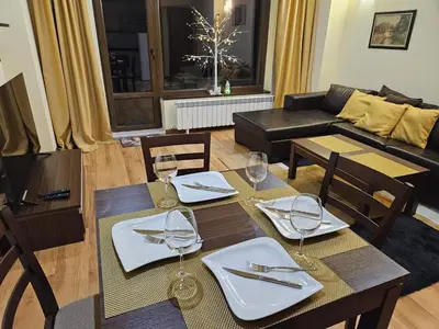 a dining room with a table and chairs with wine glasses at TERRA KOMPLEX D3 - Private apartment - Golf, Skiing & SPA in Razlog