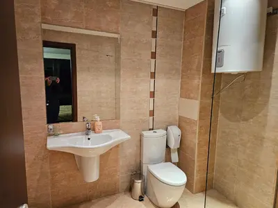 a bathroom with a toilet and a sink and a mirror at TERRA KOMPLEX D3 - Private apartment - Golf, Skiing & SPA in Razlog