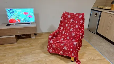 a red chair sitting in front of a tv at Aspen Suites A403 - Sky & Stars Dreamers in Razlog