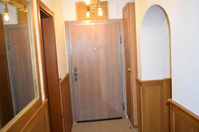 a hallway with a wooden door and a mirror at Супер луксозен апартамент в Winslow in Bansko