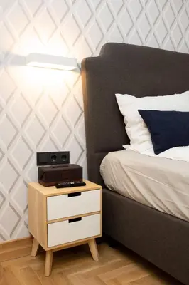 a bed with a nightstand with a clock on it at Luxury rooms 12-1 in Plovdiv