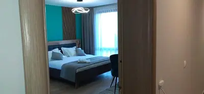 a bedroom with a bed and a window and a mirror at Apartmenthaus Oborishte in Panagyurishte