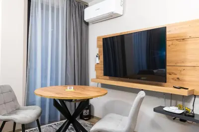 a room with a table and a tv on a wall at Apartmenthaus Oborishte in Panagyurishte