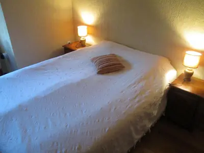 a bedroom with a large white bed with two lamps at Comfort Private Apartments in Bansko