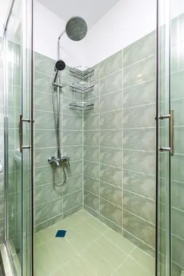 a shower with a glass door in a bathroom at A Nostalgic Getaway in Plovdiv's Historic Quarter by Flat Mаnager in Plovdiv