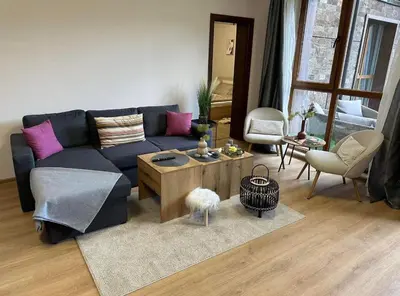 a living room with a blue couch and a table at Apart-Hotel Crown Bansko in Bansko