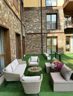 a patio with couches and chairs and a table at Apart-Hotel Crown Bansko in Bansko
