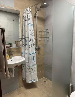 a bathroom with a shower curtain and a sink at Apart-Hotel Crown Bansko in Bansko