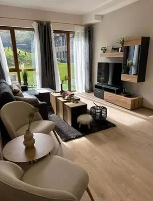 a living room with a couch and a tv at Apart-Hotel Crown Bansko in Bansko