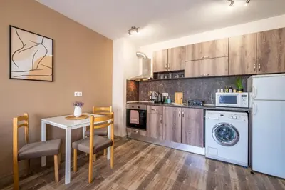 a kitchen with a washing machine and a table and chairs at Cozy Homes 1 in Sofia