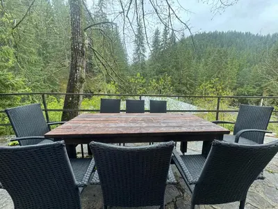 a wooden table and chairs with a view of a forest at Villa Gusto, 3km from Pamporovo in Pamporovo