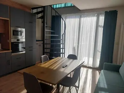 a kitchen with a wooden table and chairs in a room at Villa Doma in Sapareva Banya