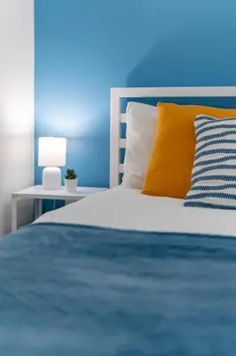a bedroom with a bed with a blue wall at Déja Blue Old City Center studio. in Sofia