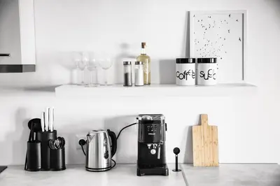 a kitchen counter with a coffee maker and wine glasses at White Сozy Studio A next to the Gondola in Bansko