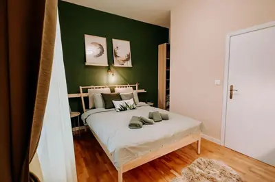a bedroom with a large bed with green walls at Artiesta - 5 apartments in Sofia
