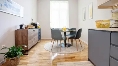 a kitchen with a table and chairs in a room at Artiesta - 5 apartments in Sofia