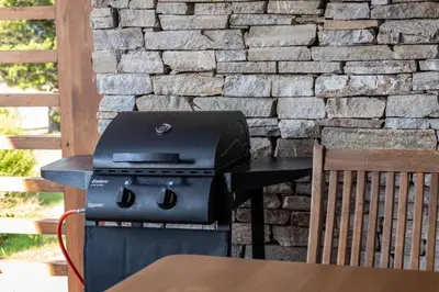 a grill sitting on a table next to a stone wall at Martini villa Lake in Razlog