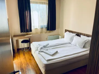 a bedroom with a bed with white sheets and a window at Lorena’s Apartment Bansko,near Gondola in Bansko