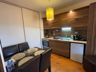 a kitchen with a table and chairs and a kitchen with a counter at Lorena’s Apartment Bansko,near Gondola in Bansko