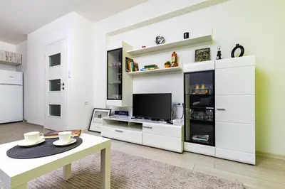 a living room with white cabinets and a tv at Radiant Retreat - Bright 1BD Haven in Plovdiv by Flat Mаnager in Plovdiv