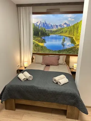 a bedroom with a large picture of a lake and mountains at Apart-Hotel Crown Bansko 2 in Bansko