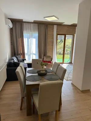a living room with a table with chairs and a couch at Apart-Hotel Crown Bansko 2 in Bansko