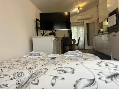 a room with a bed and a kitchen with a tv at Charming City Apartment SIYANA - Self Check-in in Panagyurishte