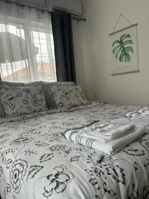 a bed with a black and white blanket and a window at Charming City Apartment SIYANA - Self Check-in in Panagyurishte