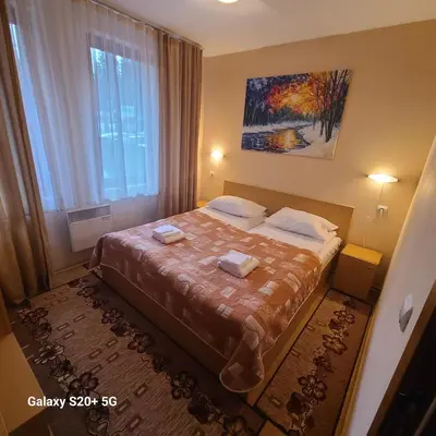 a bedroom with a bed with two towels on it at The Castle Bonko in Pamporovo