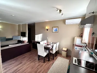 a kitchen and living room with a table and a bed at Suite in Dream Bansko in Bansko