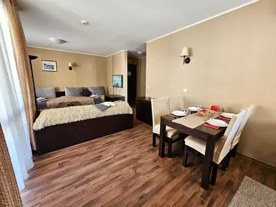 a room with a bed and a table and a dining room at Suite in Dream Bansko in Bansko