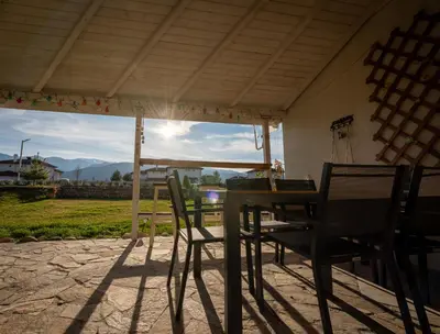 a table and chairs on a patio with a view at Къща за гости В 12 и 5 in Dolna Banya